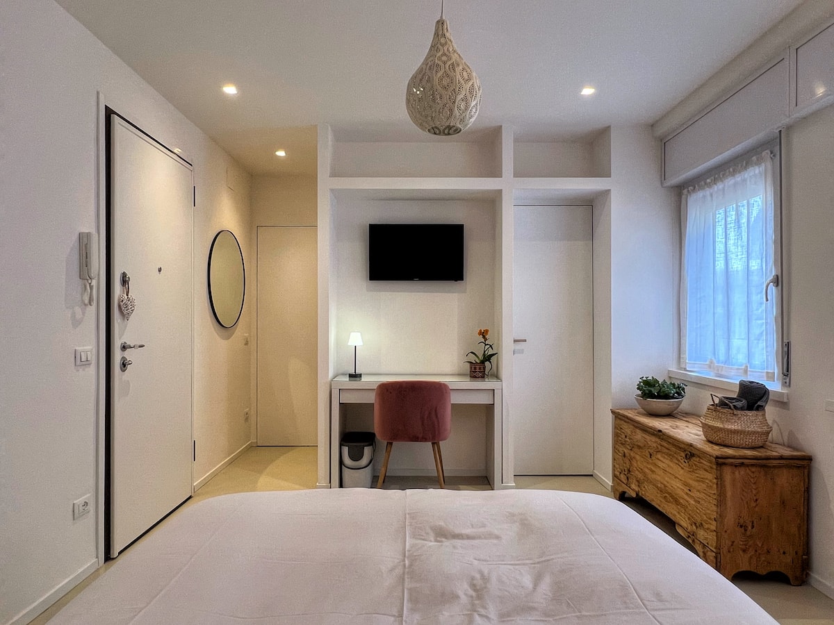 Vista completa della suite con letto matrimoniale, scrivania e ingresso indipendente